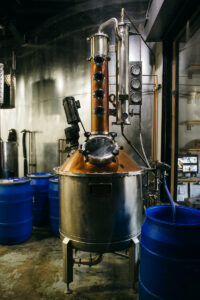 A pot still made of copper and stainless steel with a 4 plate column on top